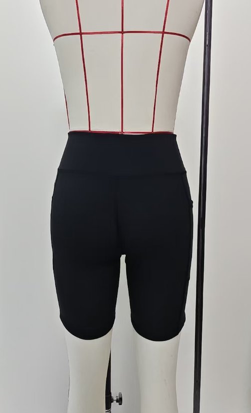 Rear view of black yoga shorts on a garment form