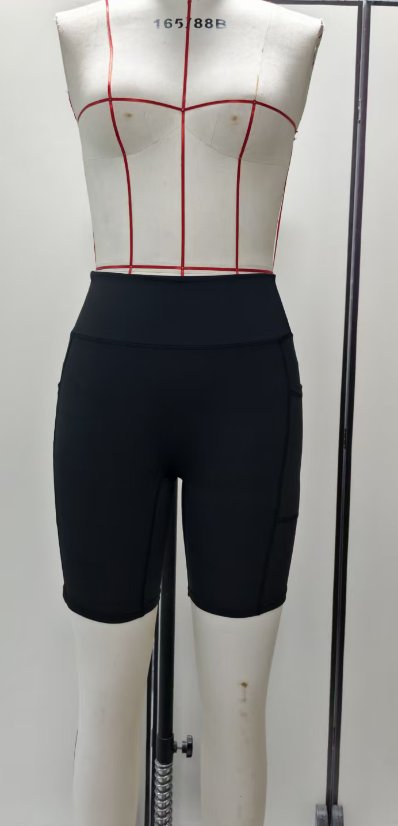 Black pocketed yoga shorts on a plain garment form